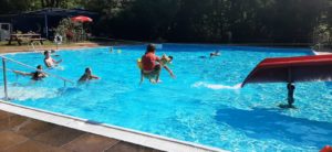 Ein Kind springt mit Anlauf in das Schwimmbecken.