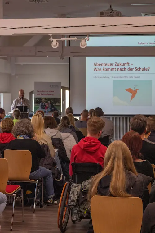 Ein Mann steht vor einem PUblikum und neben ihm ist eine Präsenation mit den Worten Abenteuer Zukunft zu sehen