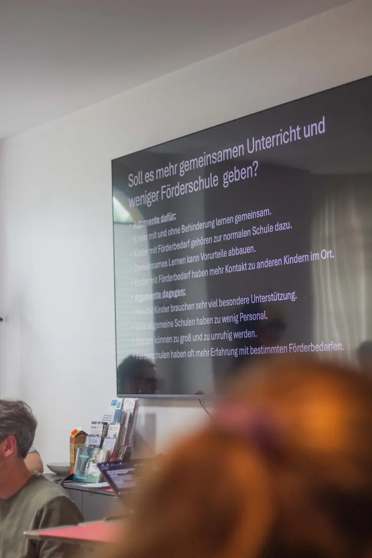 Auf einem Bildschirm steht die Frage: Soll es mehr gemeinsamen Unterricht und weniger Förderschule geben? darunter Argumente dafür und dagegen